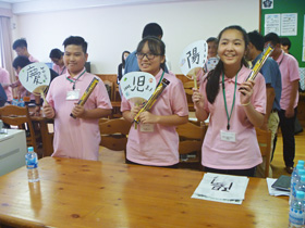 Image: Children learning Japanese calligraphy with Japanese middle school students