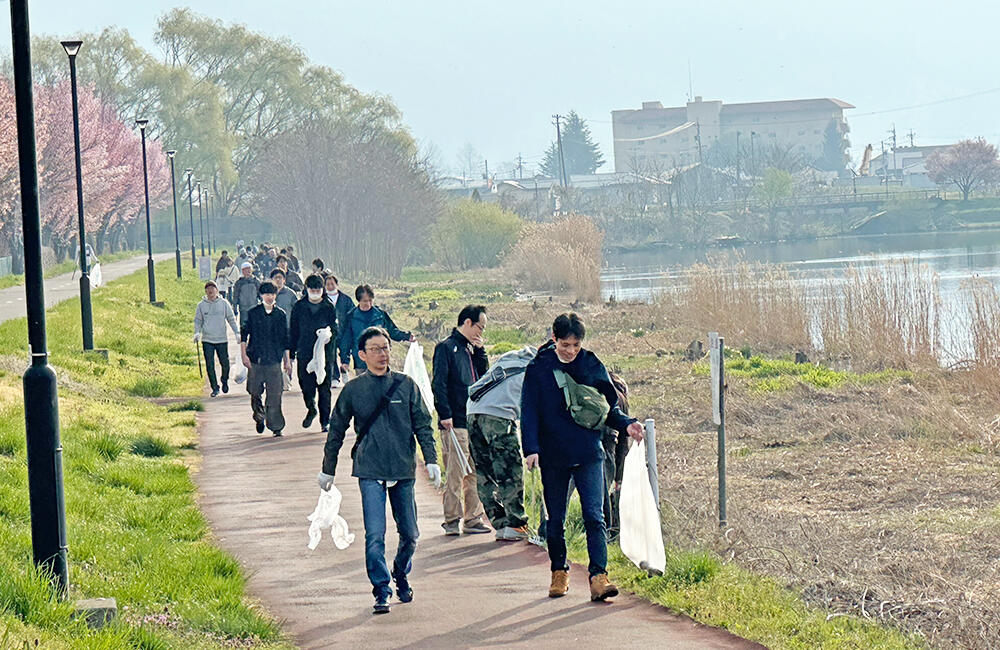 Employees participating in a cleanup activity holding garbage bags