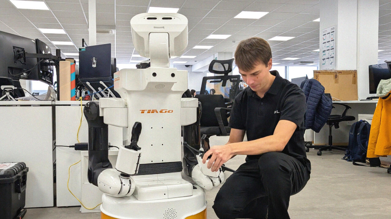 Thomas adjusting the gripper on TIAGo, the previous robot model