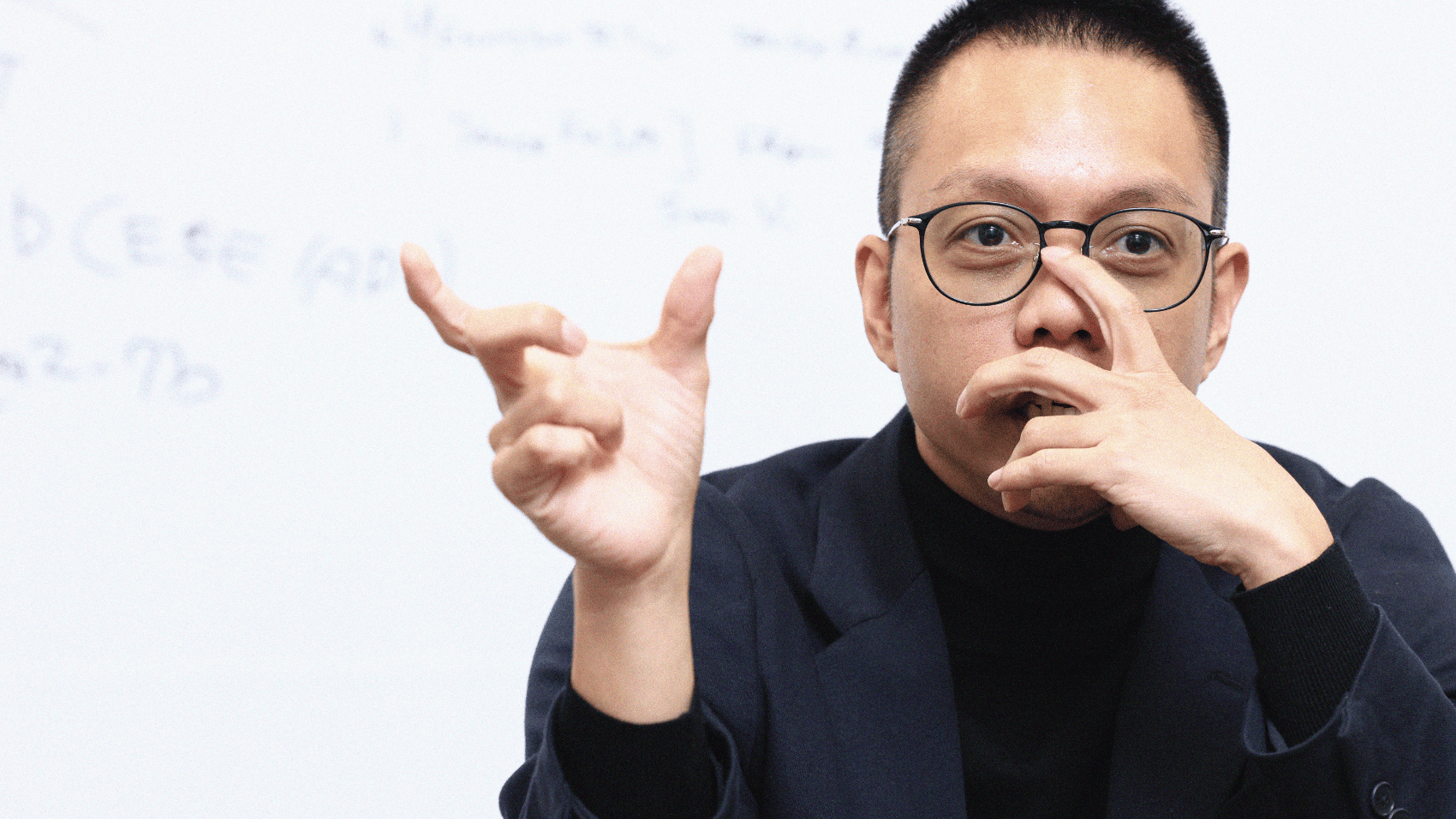 Erwin hand to his mouth, addresses us