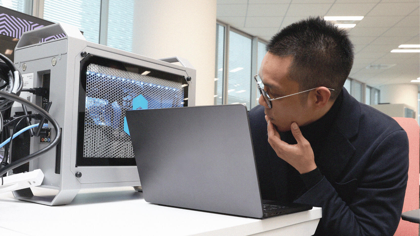 Erwin, with his hand to his chin, deep in thought in front of his PC